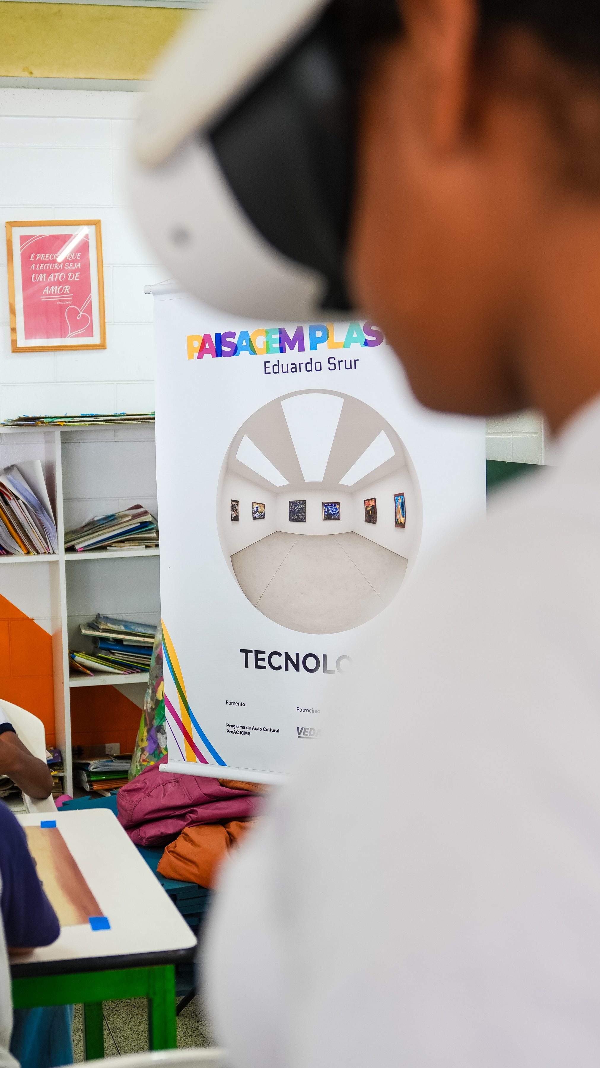 Estudante com óculos de realidade virtual diante do banner Tecnologia do projeto
