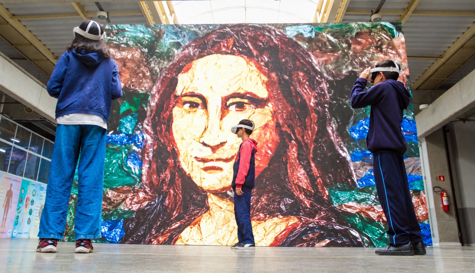 Estudiantes con gafas de realidad virtual frente a la Mona Lisa, creada a partir de residuos plásticos